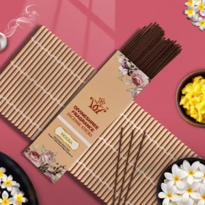 Divineshree Fragrance incense sticks with packaging and plumeria flowers on pink background.